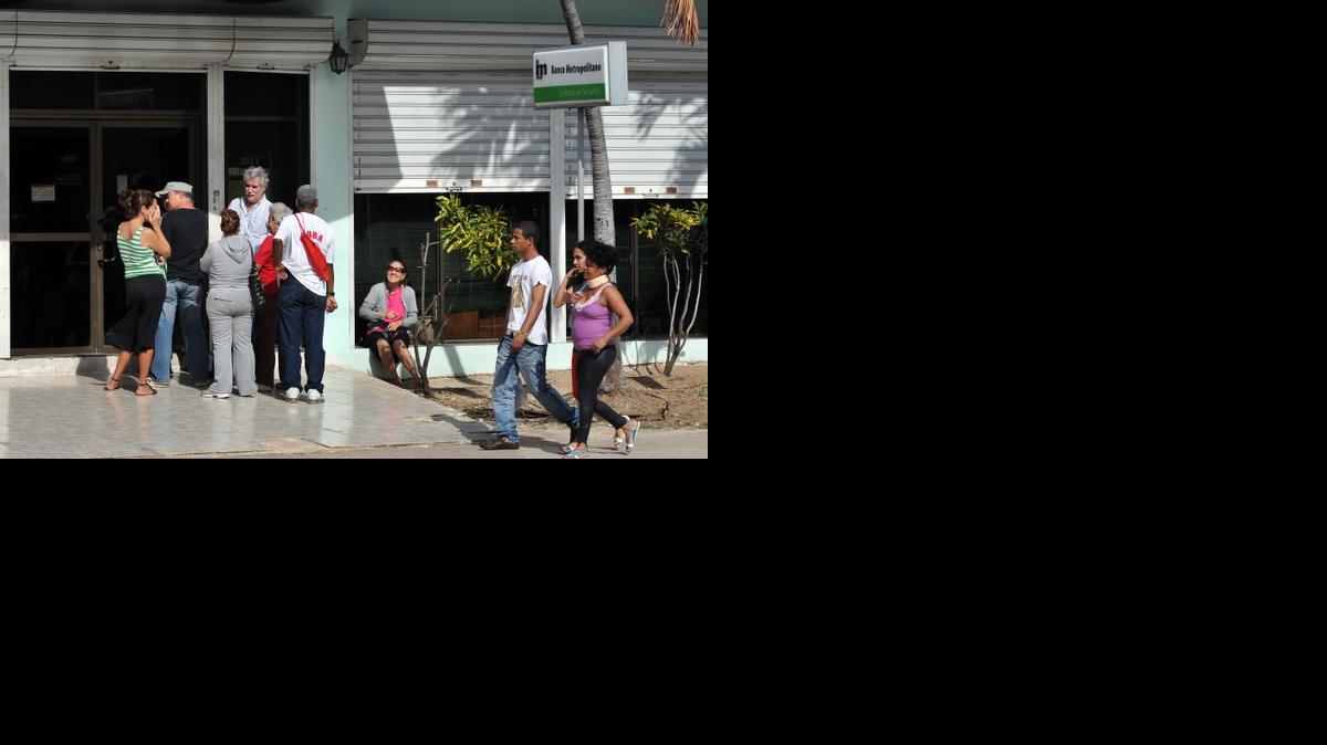 
Varias personas hacen cola a la entrada de una surcursal del Banco Metropolitano, en La Habana. Aunque las regulaciones financieras, delimitadas por la Oficina de Control de Activos Extranjeros (OFAC) en enero, permitirán a los bancos norteamericanos abrir cuentas en bancos cubanos, aún hay más preguntas que respuestas con respecto a las nuevas reglas.


