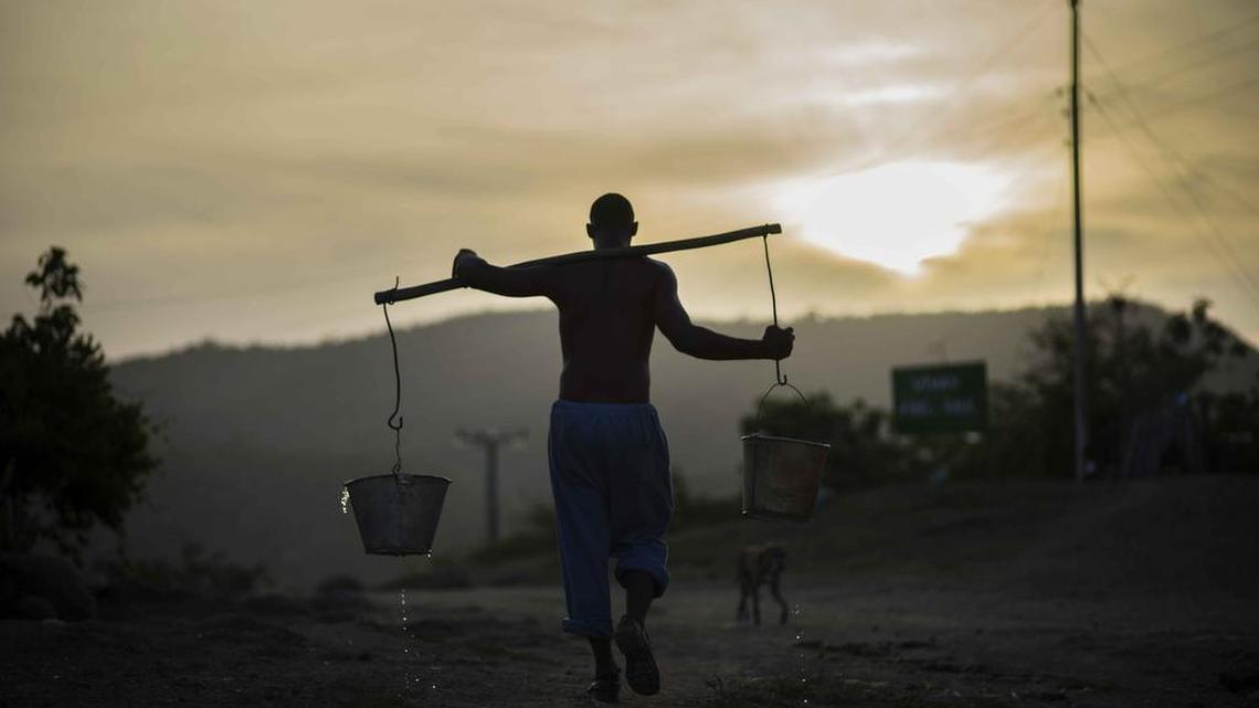 
Un hombre carga cubos de aguas en las afueras de Santiago de Cuba el pasado 27 de julio.

