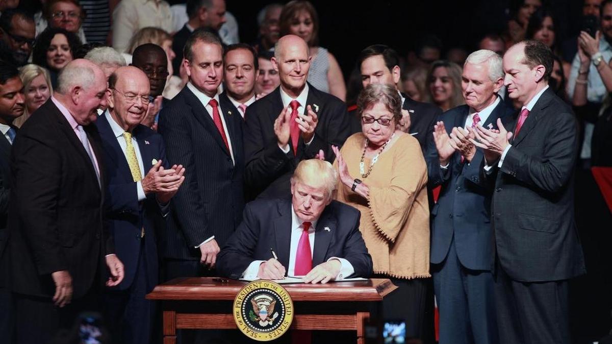 El presidente Donald Trump firma un memorando sobre Cuba junto al vicepresidente Mike Pence, en el teatro Manuel Artime de la Pequeña Habana en Miami.
