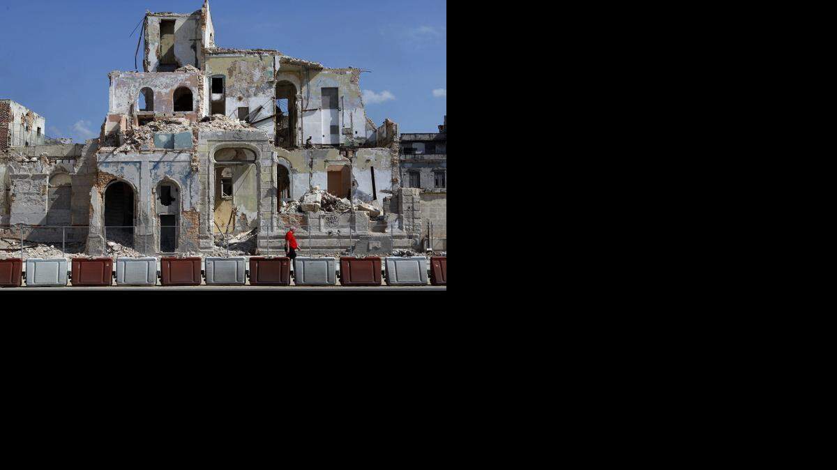 
Un hombre camina junto a un edificio en ruinas en La Habana el martes 10 de abril de 2012.
