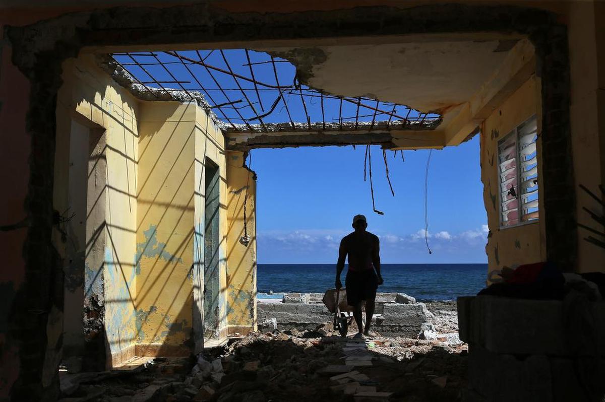 Un hombre bota escombros de las ruinas de su casa el viernes 15 de septiembre, en el poblado de Cojímar, en La Habana (Cuba), casi una semana después del paso del huracán Irma.