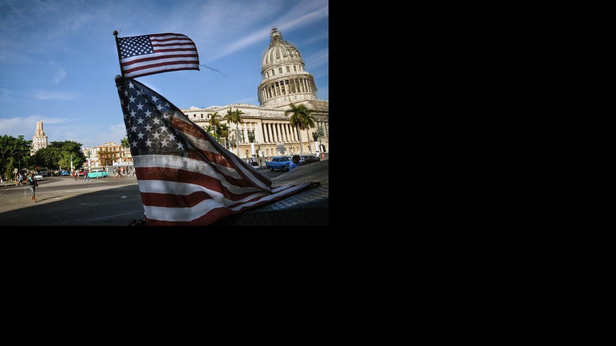 
Una bandera de Estados Unidos ondea en un bicitaxi en La Habana, con el Capitolio en el fondo.  
