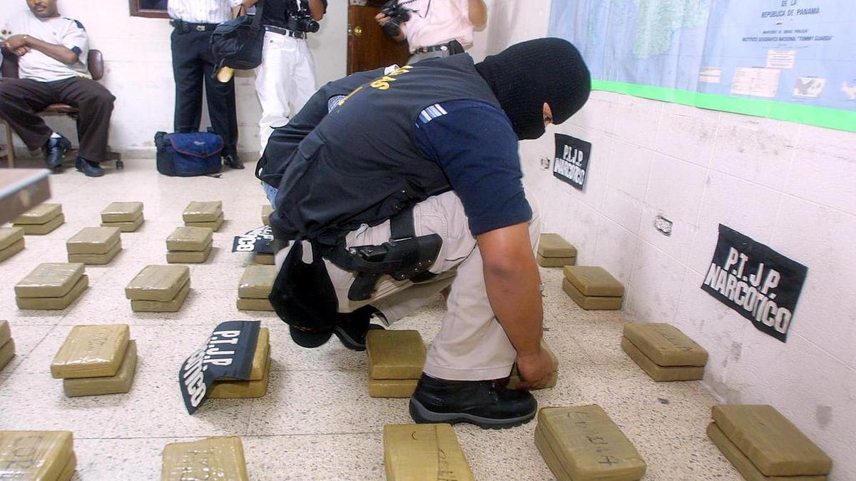 Un inspector de la Policía Técnica Judicial (PTJ) acomoda paquetes de cocaina decomisados en Ciudad de Panamá en octubre del 2002.