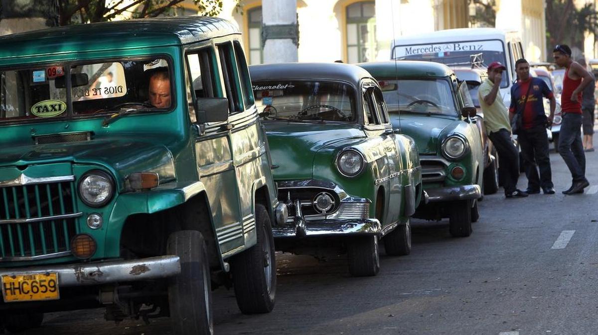 Varios taxistas privados conversan a la espera de clientes en La Habana. Ahora enfrentan la disyuntiva de tener que reajustarse a las nuevas tarifas o dejar el negocio.