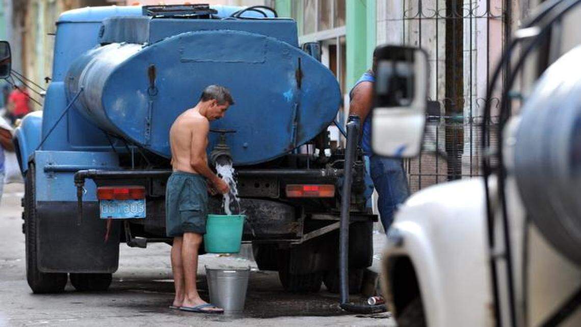 
Un hombre carga agua de un camión cisterna en La Habana, donde es común en diversos barrios la escasez de este vital líquido. Foto de archivo. 


