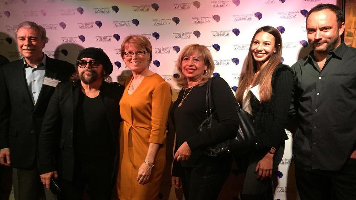 El ex secretario de Comercio, Carlos Gutiérrez posa junto al músico cubano Carlos Varela y la directora del Center for Democracy in the Americas, Sarah Stephens (en el centro), durante la celebración del décimo aniversario del Centro para la Democracia en las Américas, en Washington, el 13 de noviembre.