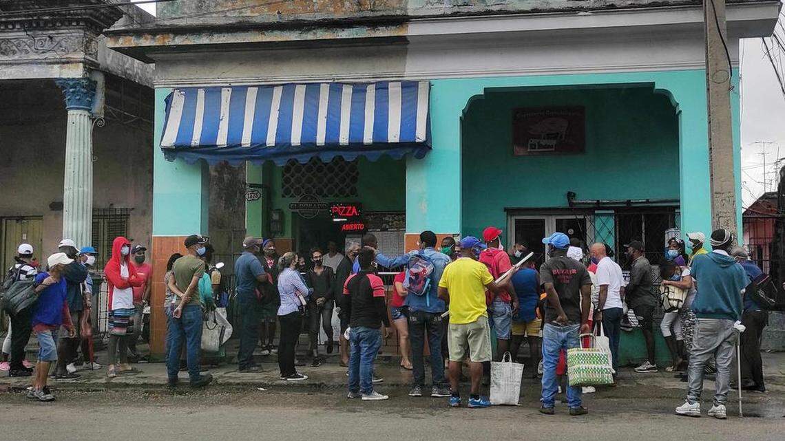 People wearing face masks as a precautionary measure against the spread of COVID-19 line up to buy food in Havana on March 22, 2021.