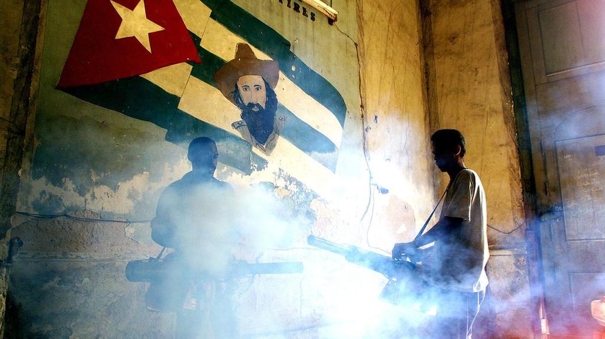 Trabajadores del Ministerio de Salud Pública fumigan contra el dengue la entrada de un viejo edificio en La Habana Vieja, el 19 de octubre del 2000.