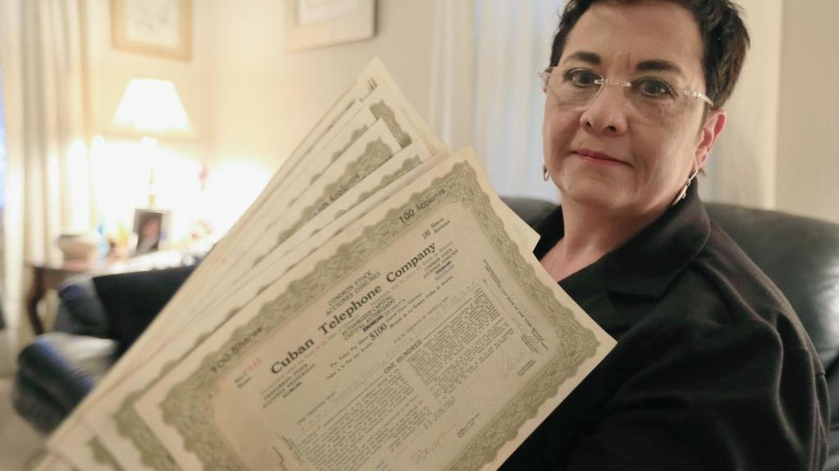 En esta foto de archivo Carolyn Chester muestra certificados de acciones de la Compañía Telefónica de Cuba que fue confiscada por el gobierno de Castro hace décadas.