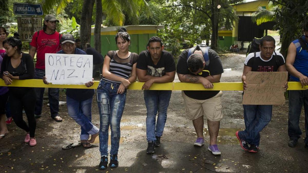 Migrantes cubanos muestran un cartel en contra del presidente de Nicaragua Daniel Ortega y otro que pide libertad, luego de que el gobierno nicaraguense echara por la fuerza a cientos de cubanos hacia Costa Rica.