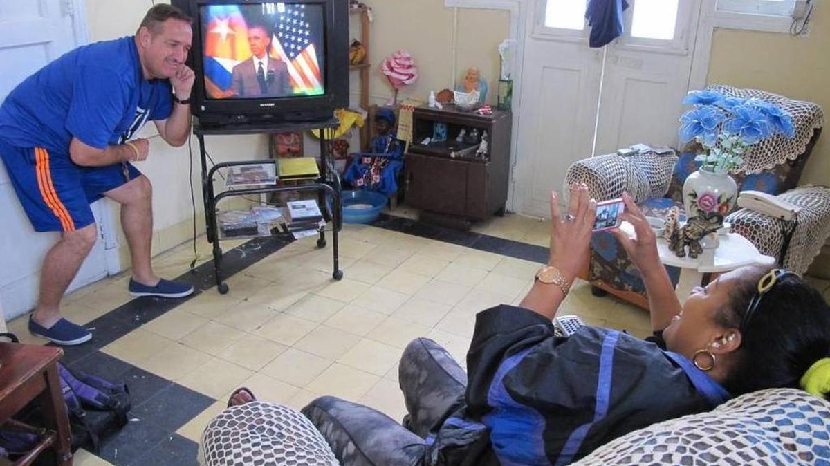 María Lastres toma una foto con el teléfono a su esposo, Jesús Magán, mientras ven el discurso del presidente Obama desde su apartamento en La Habana.