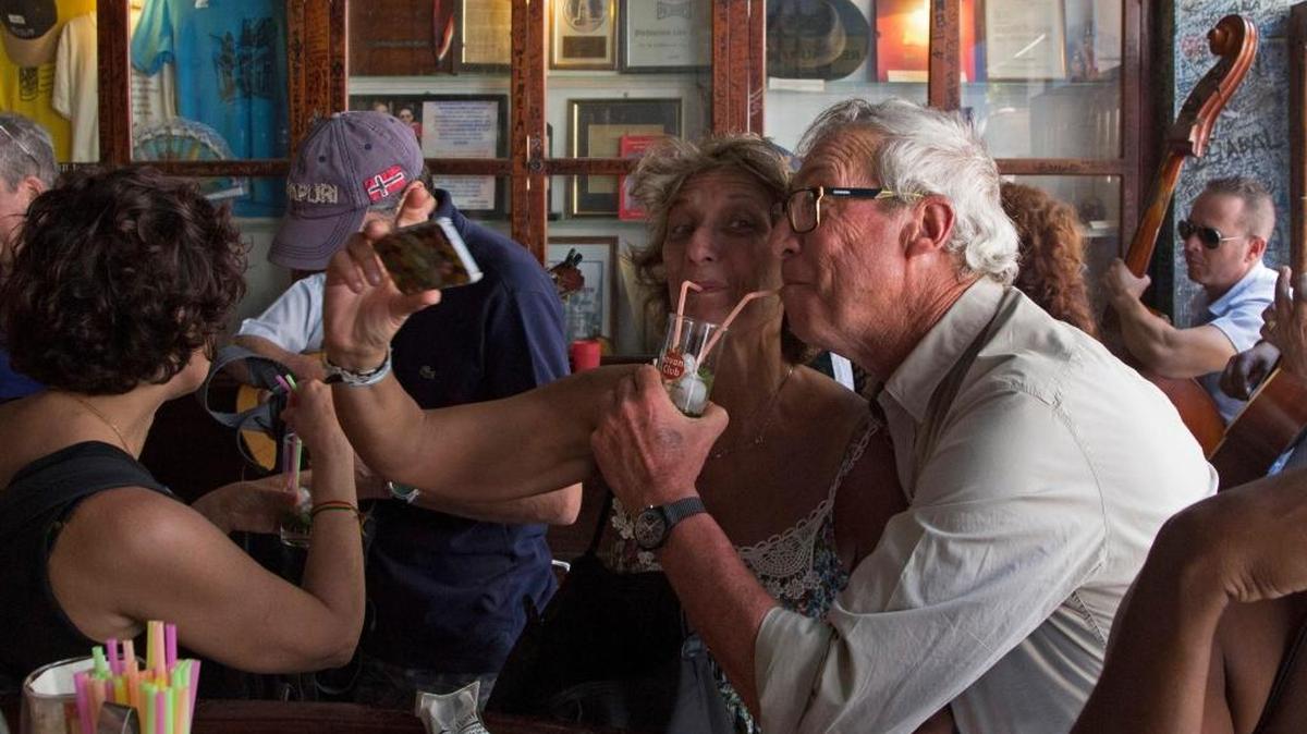Turistas disfrutan de sus tragos en la Bodeguita del Medio en La Habana Vieja. Aunque ciertas marcas cubanas de ron y refrescos están en la lista de prohibiciones de Estados Unidos, el Departamento de Estado ha aclarado que pueden comprarlos en la isla mientras no sea directamente al fabricante.