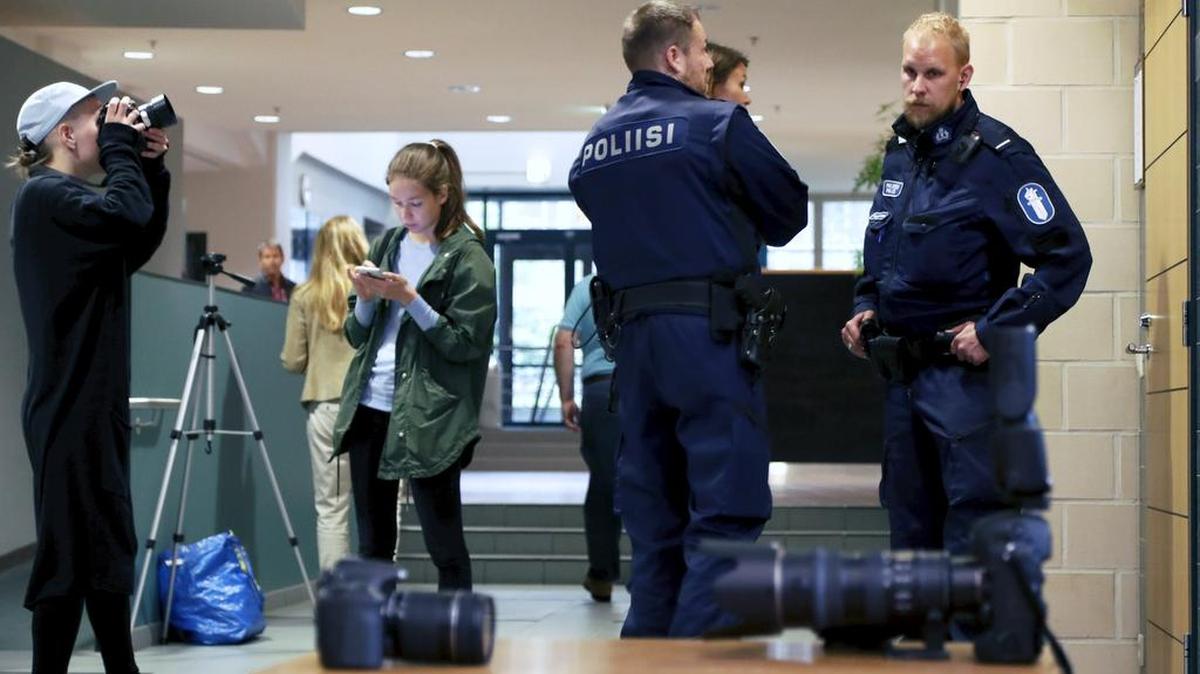 Miembros de la prensa y agentes policiales en Finlandia trabajan en el caso de los voleibolistas arrestados.