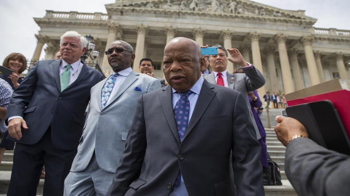 El representante demócrata John Lewis (der) encabeza una protesta de legisladores en la escalinata del Capitolio en Washington el 23 de junio del 2016.