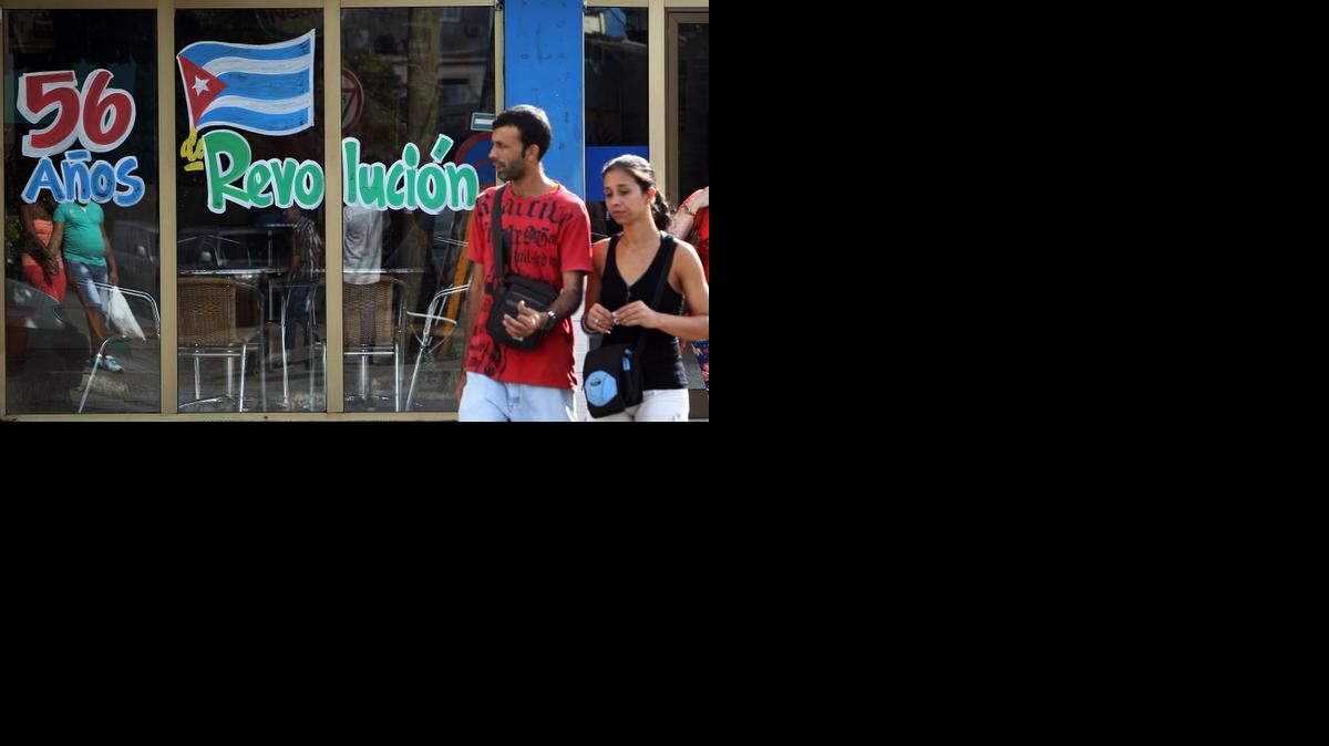 
Una pareja camina el miércoles 31 de diciembre de 2014 frente a un grafiti alusivo al nuevo aniversario de la Revolución cubana, en La Habana (Cuba). Los cubanos esperarán esta noche la llegada de 2015 fieles a la tradición de celebrar en familia y con renovadas expectativas por la etapa que se abre con EEUU, en una jornada ensombrecida, sin embargo, por las detenciones de varios opositores en la víspera, algunos de ellos ya en libertad. 
