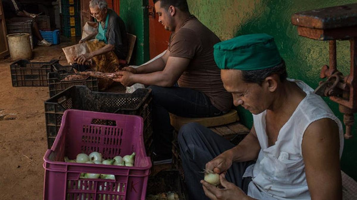 Varios Empleados limpian vegetales en un mercado ubicado en la barriada de Centro Habana.