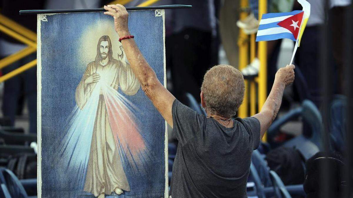 
Una mujer cubana copn una imagen de Cristo y la bandera de su país en la Plaza de la Revolución de La Habana, donde el Papa oficiará su primera misa en Cuba, a la que asistirán miles personas que ya están congregadas en el que se considera uno de los lugares más emblemáticos del país y a la que también asisten el presidente cubano Raúl Castro, y la mandataria argentina Cristina Fernández. 
