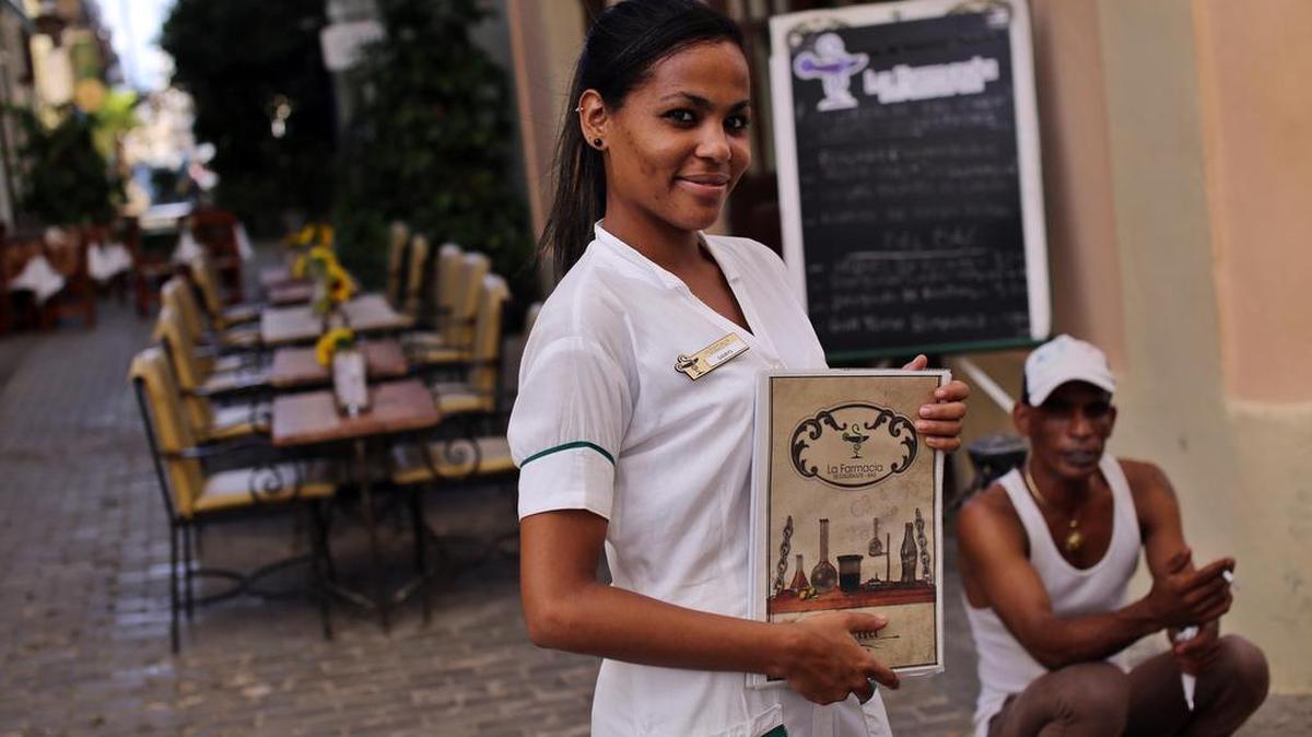 Una mesonera posa mientras espera la llegada de clientes en un restaurante privado en La Habana (Cuba) el lunes 17 de octubre de 2016.
