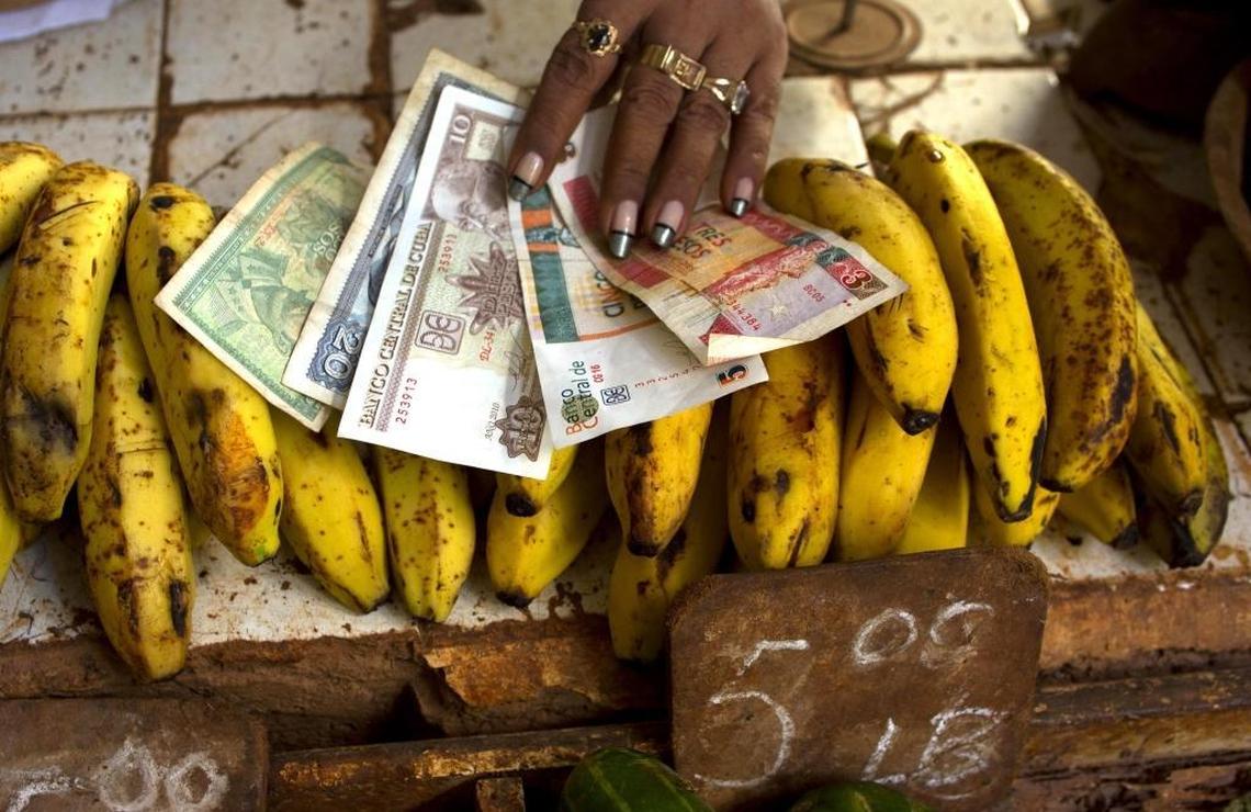 A food vendor at a Havana agro-market shows Cuban convertible pesos (CUCs) on the right and Cuban pesos (CUPs) on the left. Cuba uses both currencies and has multiple exchange rates.