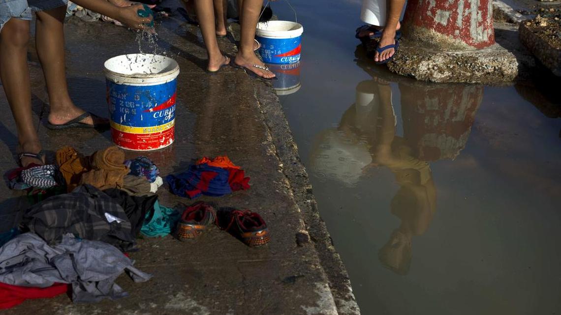 Damnificados por el huracan Matthew lavan la ropa en un sitio provisional en Baracoa, Cuba.