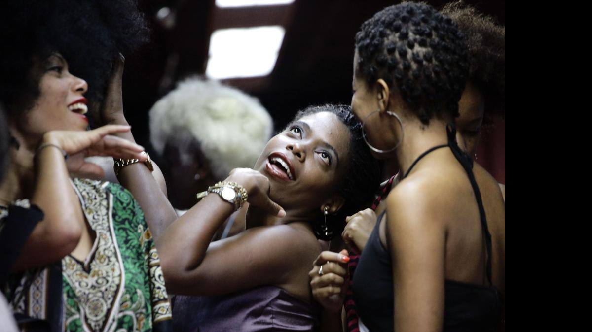 
Participantes en el consurso de ‘afros’ bromean mientras esperan para caminar por la pasarela, en La Habana.
