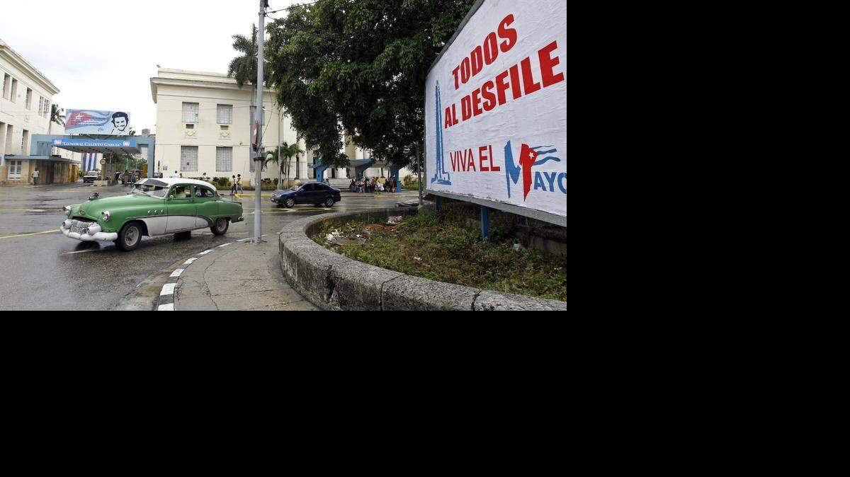 Vista de un auto el jueves 30 de abril del 2015, frente a un cartel alusivo al desfile que organiza el gobierno cubano para este 1ro de mayo.