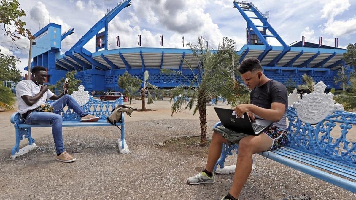 Manuel Méndez (izquierda) y Pedro Jordán aprovechan el WiFi gratis frente al Estadio Latinoamericano en La Habana.
