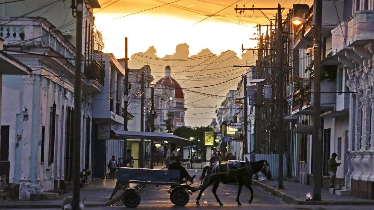 Un carruaje tirado por caballo al atardecer en las calles de Cienfuegos, Cuba.