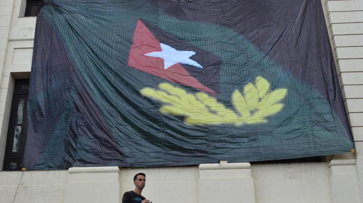 Un joven pasa frente a un cartel con una imagen alusiva al fallecido líder cubano Fidel Castro el domingo 27 de noviembre de 2016, en La Habana (Cuba).