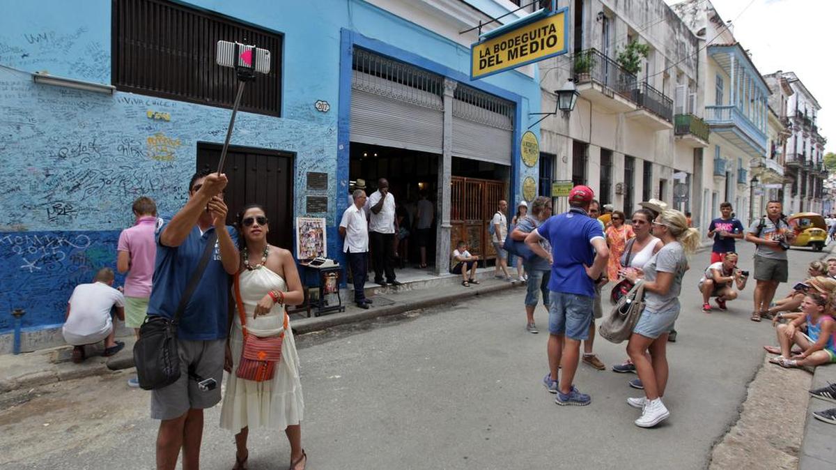 
Turistas se toman fotos en la entrada del restaurante "La Bodeguita del Medio" en La Habana Vieja este 11 de agosto de 2015. Ante la previsible llegada de ferrys, cruceros y más aerolíneas en los próximos meses, Cuba se prepara para una avalancha de visitantes estadounidenses con proyectos para ampliar puertos, aeropuertos y plazas hoteleras, pero entre dudas sobre si sus endebles infraestructuras soportarán esa presión. 

