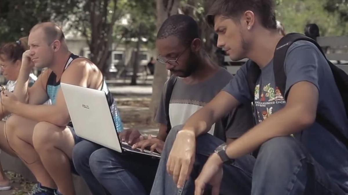 Josuhe Pagliery (primero a la derecha) y Johann Armenteros (segundo desde la derecha), del estudio Empty Head Games, se conectan a internet en un punto wifi en La Habana, Cuba.