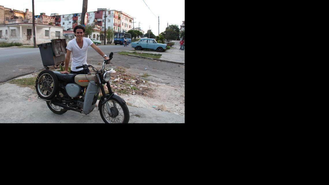 
Rainer Quintero posa junto a la moto Simson de su padre en La Habana. Roberto Quintero, que estudió en la RDA, la recibió de regalo de sus amigos alemanes a comienzos de los años 90.
