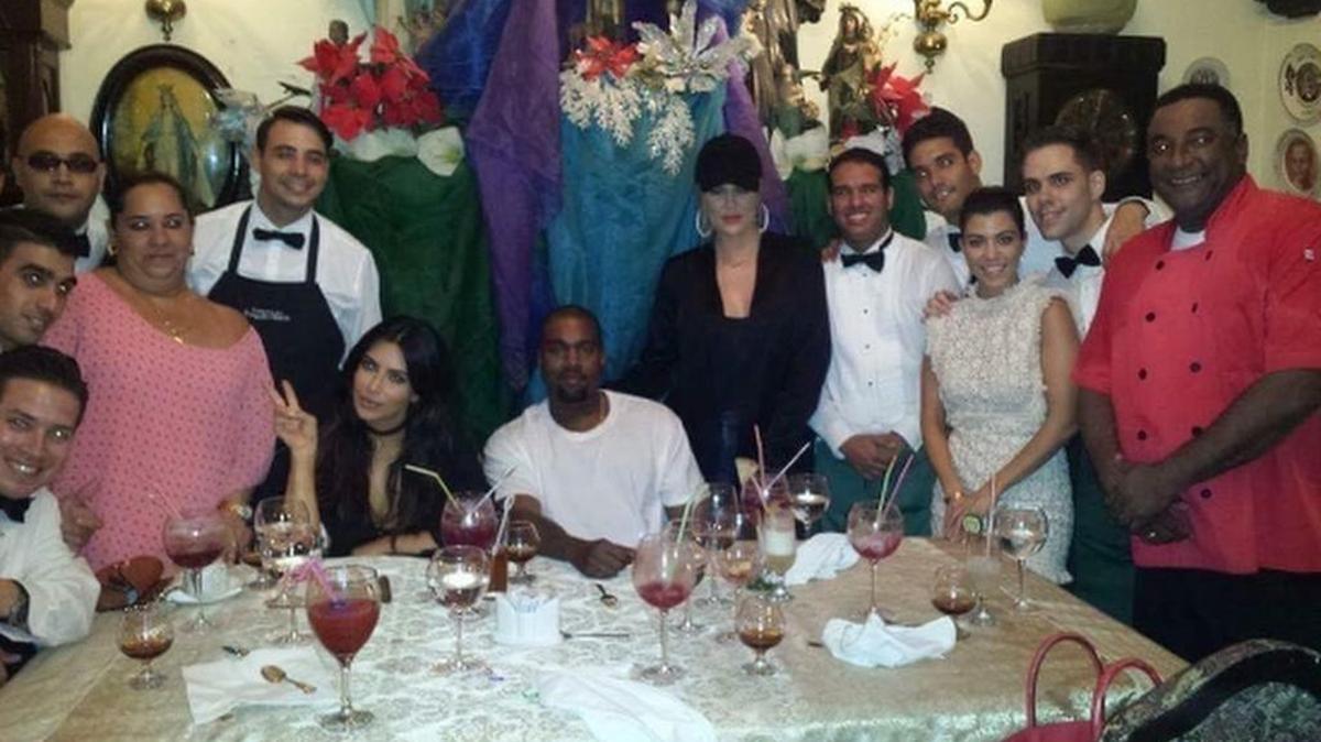 Kim Kardashian, su esposo Kanye West, y sus hermanas Kourtney y Khloe, se toman una foto con empleados del restaurante San Cristóbal en La Habana.