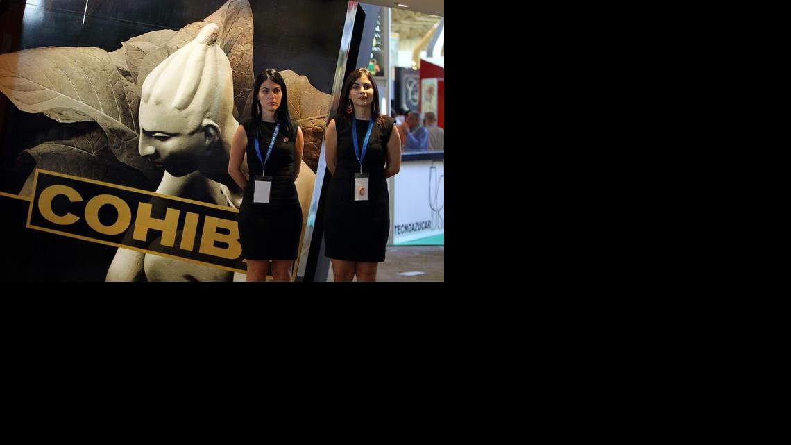 
Dos promotoras posan cerca de una publicidad de Cohíba durante la XXX Feria Internacional de La Habana, en noviembre de 2012. 
