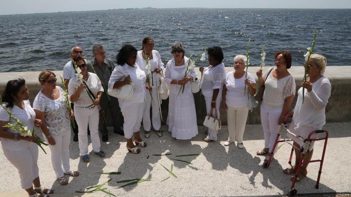 
Mujeres parte del grupo opositor cubano Damas de Blanco arrojan flores al mar durante un evento conmemorativo este domingo, 13 de septiembre, en los predios de la Ermita de la Caridad.

