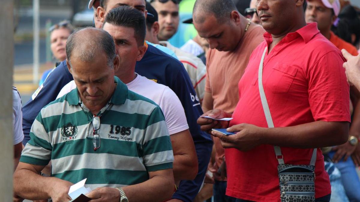Decenas de cubanos hacen fila hoy, 10 de febrero de 2016, en la ciudad de David, capital de la provincia occidental panameña de Chiriquí, para comprar el boleto de avión, por 523,50 dólares cada uno, para viajar a México.
