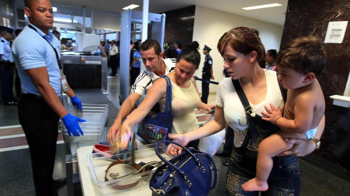 Migrantes cubanos pasan un control de seguridad para viajar de Panamá con dirección a Ciudad Juárez (México) el martes 10 de mayo de 2016, como parte de un puente aéreo humanitario, en la terminal internacional del aeropuerto de Tocumen en Ciudad de Panamá (Panamá).