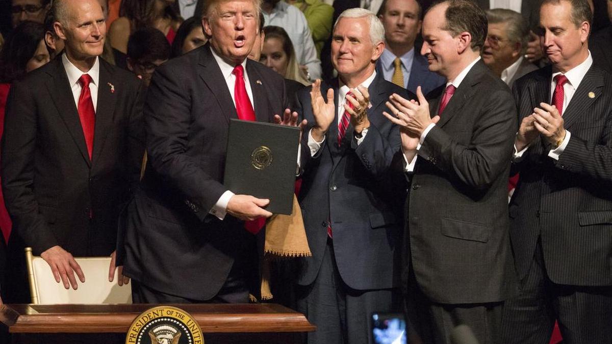 El presidente estadounidense, Donald J. Trump, muestra el memorando presidencial sobre la política con Cuba al finalizar su discurso en el teatro Manuel Artime de la Pequeña Habana, en Miami, el 16 de junio de 2017.