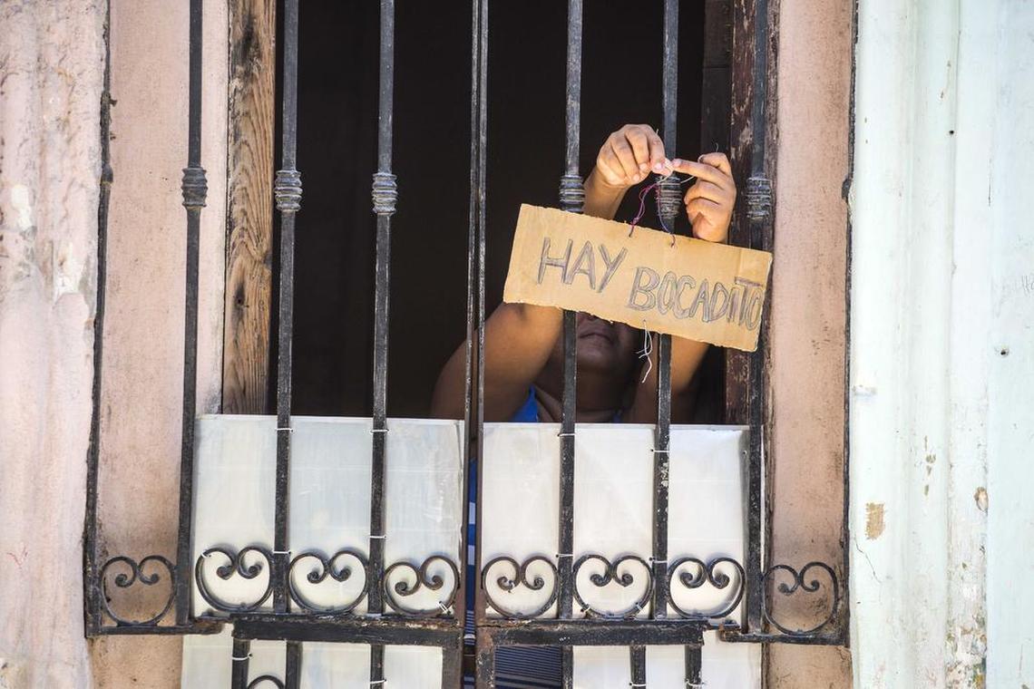 Some cuentapropista operations are small. Here a woman places a sign  in the doorway of her home that advertises “bocadito” (snacks) are for sale.