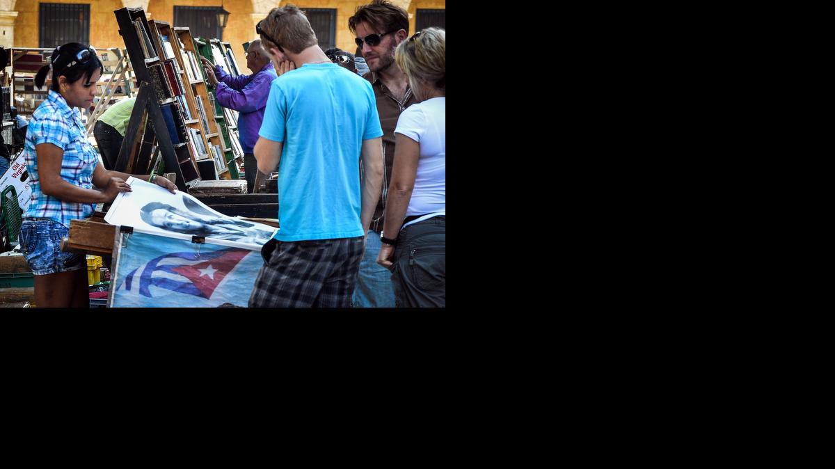 
Turistas miran carteles en venta en una librería de uso callejera en La Habana Vieja la semana pasada.
