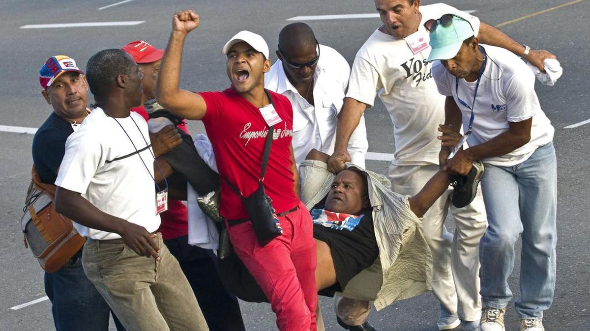 Oficiales de seguridad vestidos de civil se llevan detenido a un hombre que corrió agitando una bandera de Estados Unidos momentos antes del inicio de la marcha del 1o de mayo en La Habana, Cuba, el lunes 1 de mayo de 2017.