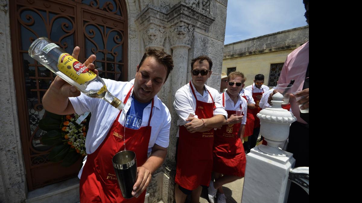 
El barman estadounidense John Christian Lermayer (izq.), quien ganó mención de honor en el concurso ‘Rey del Daiquiri’, prepara uno de estos cocteles el viernes, en la tumba de Constantino ‘Constante’ Ribalaigua, en el Cementerio de Colón de La Habana. ‘Constante’ fue dueño del célebre bar ‘Floridita’ y es considerado como padre del Daiquirí. 
