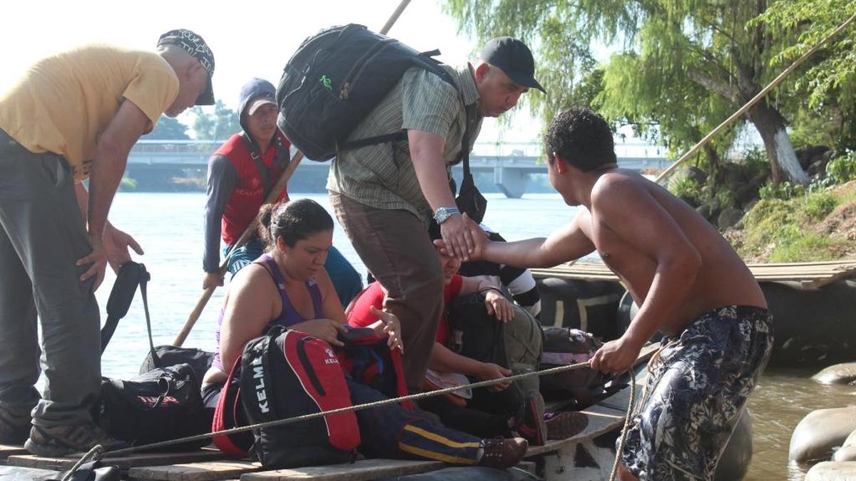 Decenas de migrantes cubanos cruzan este viernes el río Suchiate, en la frontera de México con Guatemala.