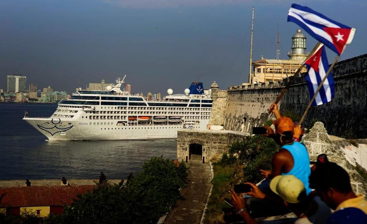 Gente con banderas cubanas saludan a pasajeros en el barco de cruceros Adonia de Carnival cuando llega de Miami a La Habana en mayo de 2016.