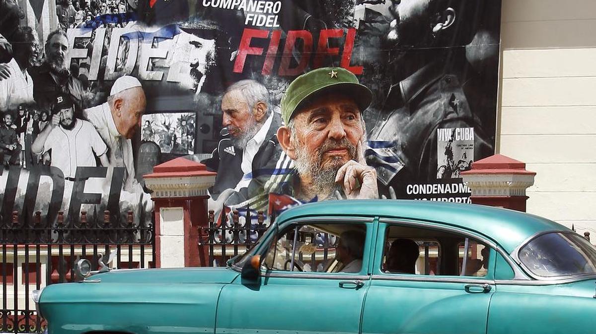 Un coche clásico pasa frente a un gran cartel con diferentes imágenes del líder de la revolución cubana Fidel Castro, en el día de su 91 cumpleaños, el domingo 13 de agosto del 2017, en La Habana (Cuba).