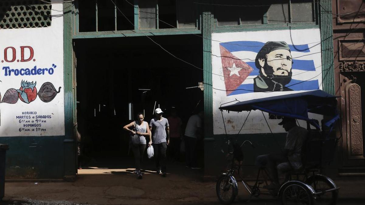 Clientes salen de un mercado agrario estatal donde un mural de Fidel Castro decora la fachada, en La Habana, Cuba, el jueves 7 de marzo de 2024.