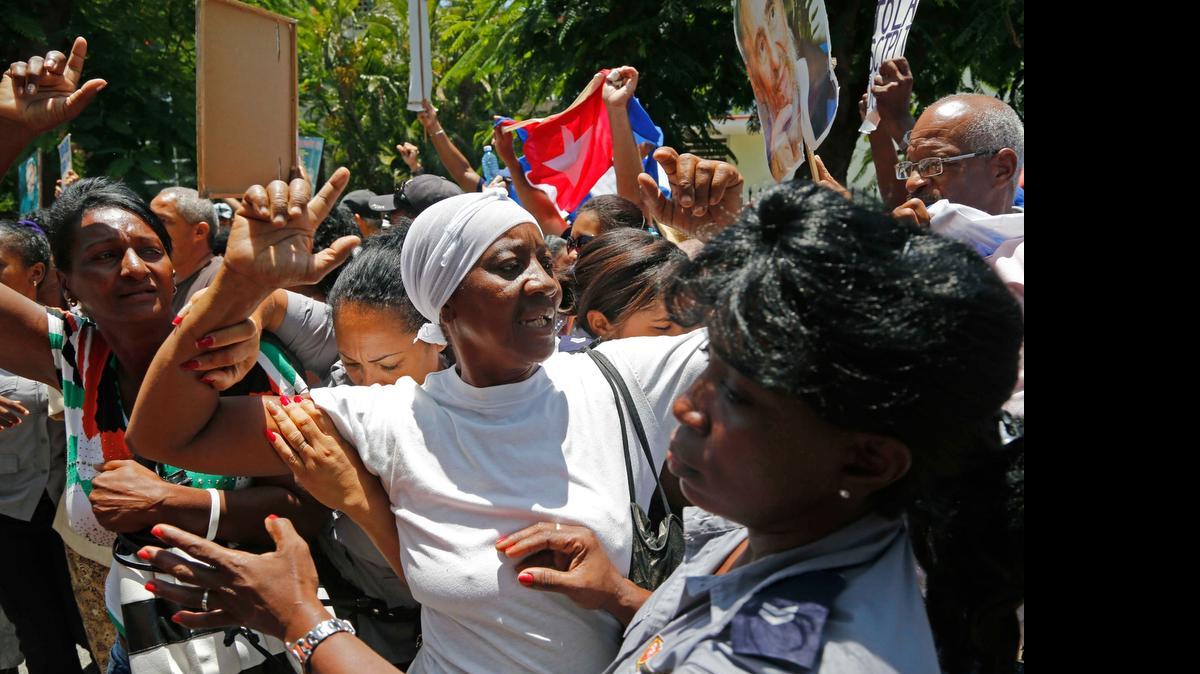 
Integrantes de las Damas de Blanco son detenidas por agentes policiales cubanos el domingo, en La Habana.

