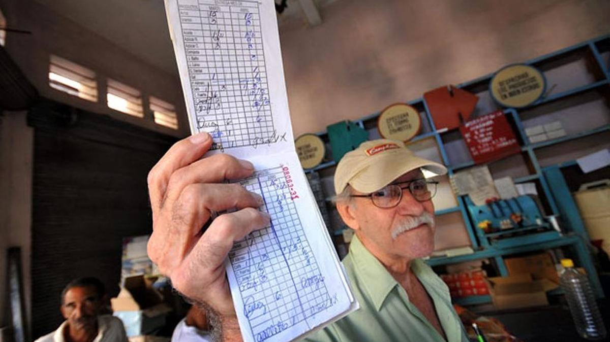 Un anciano muestra la libreta de racionamiento en un mercado subsidiado por el gobierno