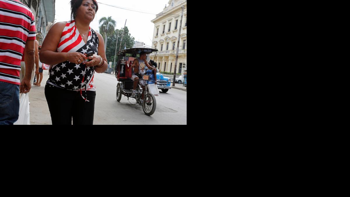 
Los cubanos comunes ven el futuro con una mezcla de candidez, temor, esperanzas y sobre todo con muchos deseos de que su situación actual cambie para bien. En la foto, una mujer viste una blusa con la bandera americana en La Habana.
