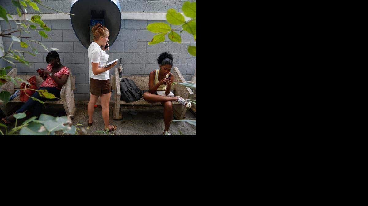 
Tres jovencitas usan servicios de telecomunicaciones, incluyendo internet, en el centro del artista Kcho, aprobado por el gobierno, en La Habana.
